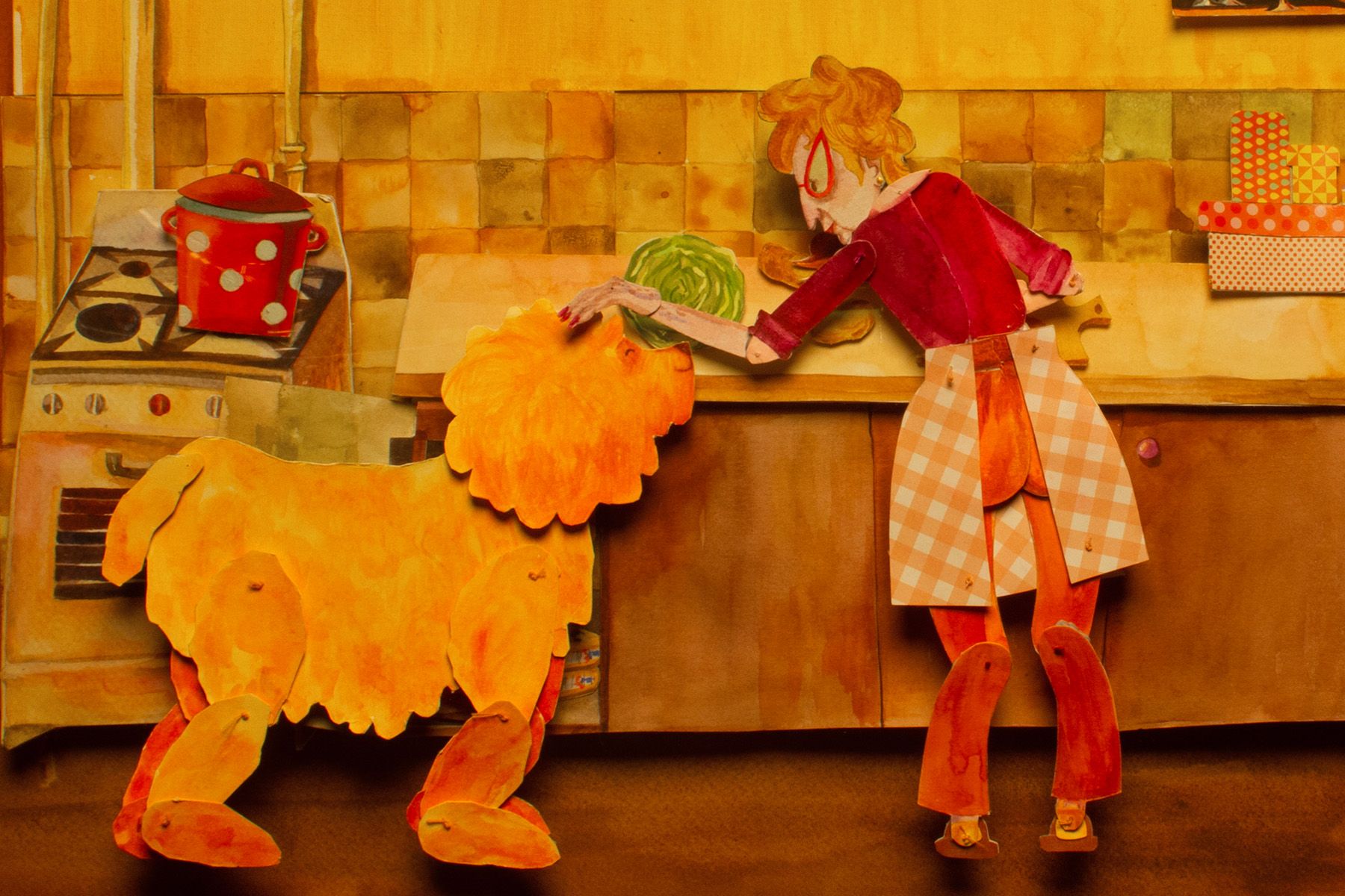 אישה במטבח מאכילה אריה מגזרות נייר