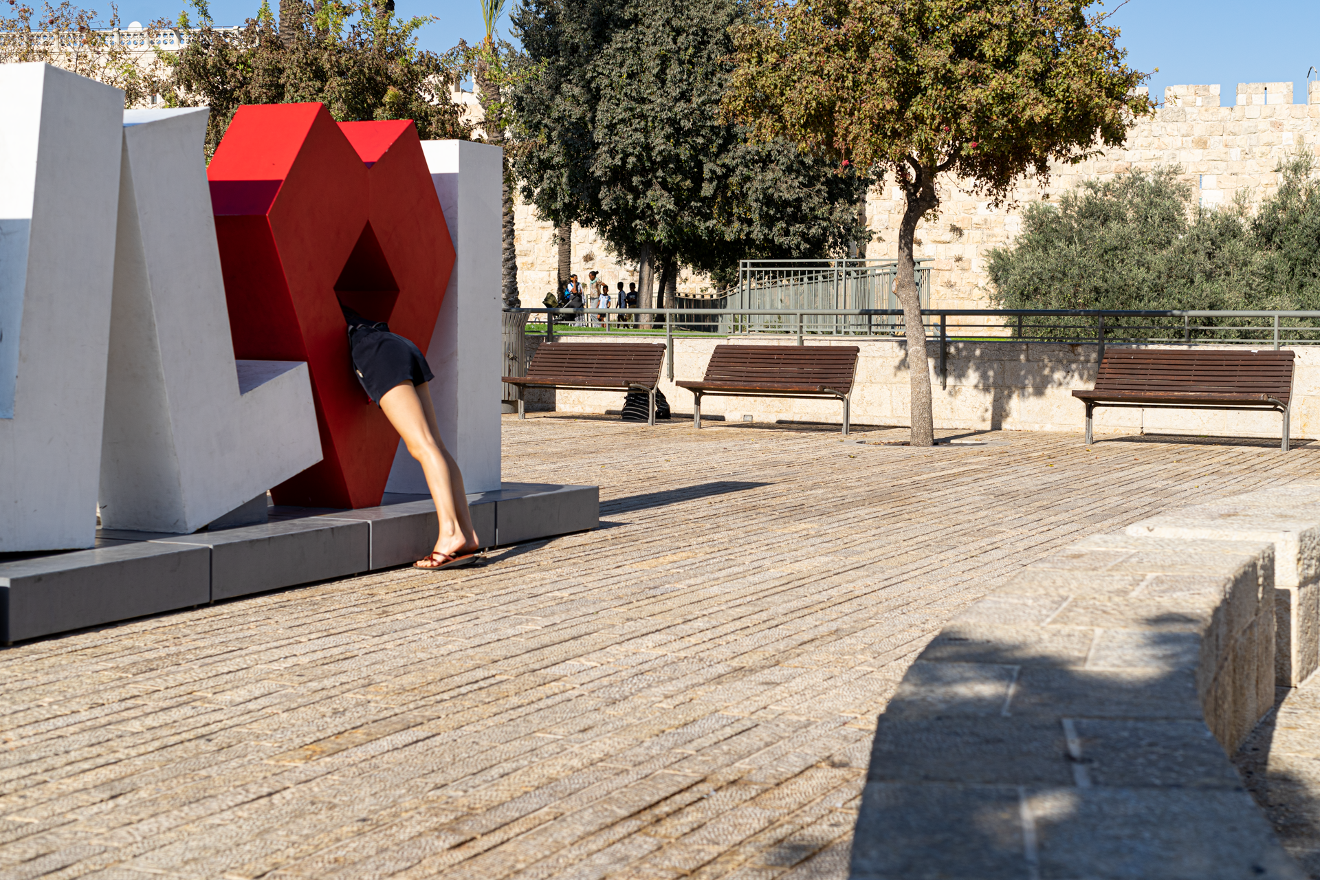 תמונה של אישה נכנסת לתוך פסל אותיות -  מתוך התערוכה פוטוריזם ירושלמי - עבודות סטודנטים במחלקה לצילום
