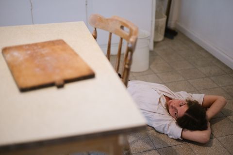 אישה שוכבת על רצפה במטבח
