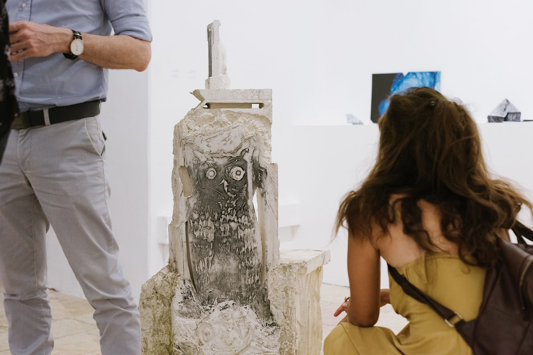 דמות של אישה מול פסל בתערוכה