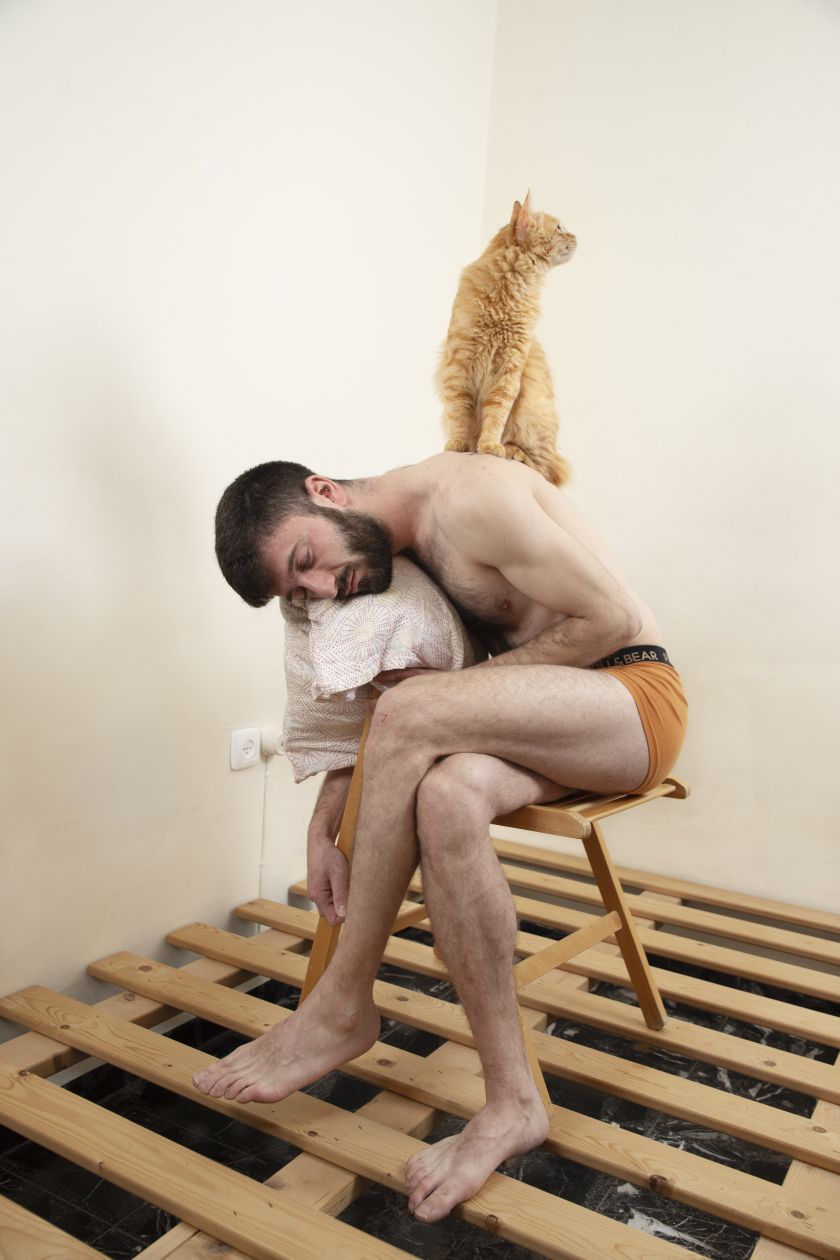 איש יושב ועליו חתול